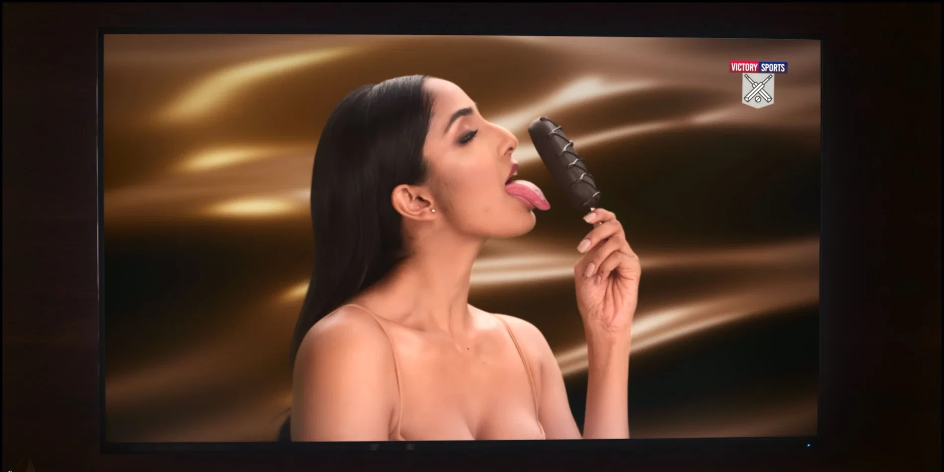 Aishwarya Sushmita posing licking ice cream in a glamorous outfit featuring a deep cleavage neckline.