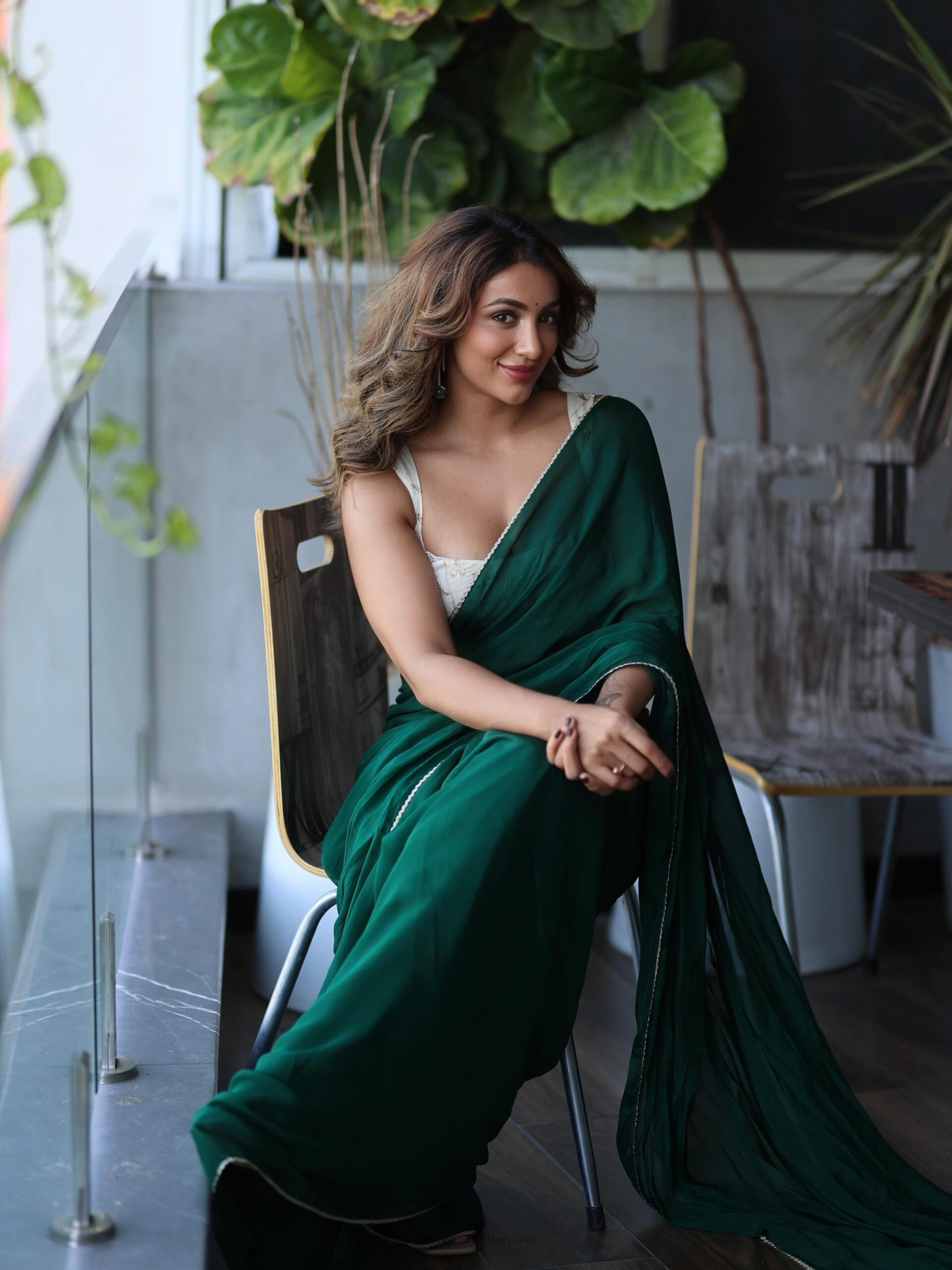 Close up glamorous shot of actress Tejaswi Madivada wearing a bold low neck sleeveless designer blouse with a sheer black lace saree.