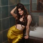 Divya Bharathi posing in a simple black bra top and a contrasting bright yellow bottom, professional fashion photography, minimal studio setup