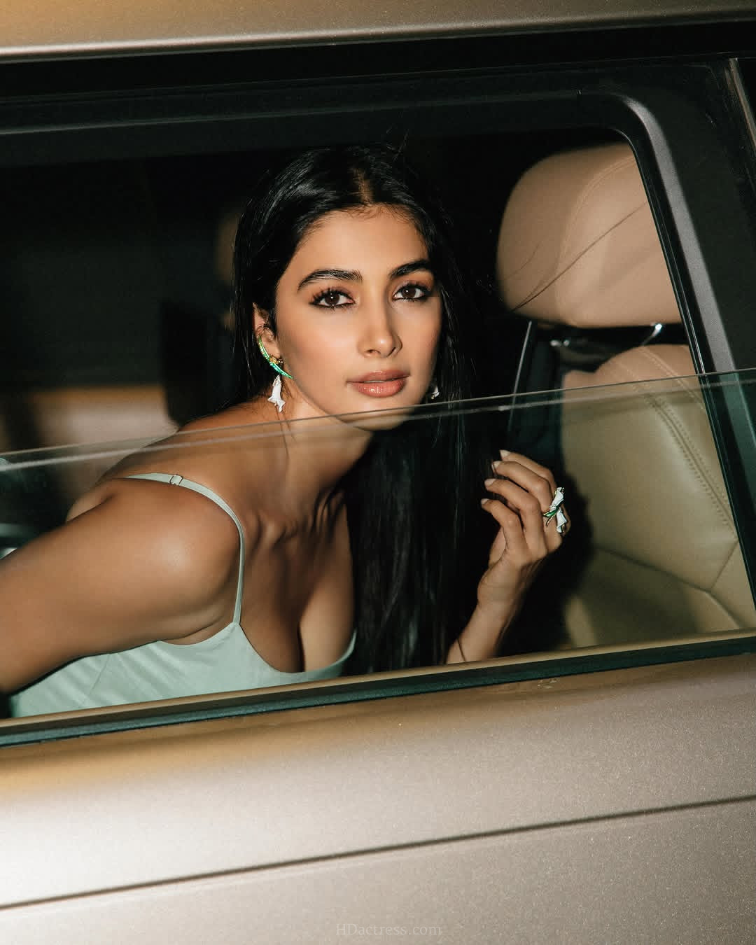 Pooja Hegde posing gracefully in a sleek satin slip dress, Pooja Hegde showcasing a bold low cut neckline outfit, close up photo of Pooja Hegde looking stunning in a sultry designer slip dress