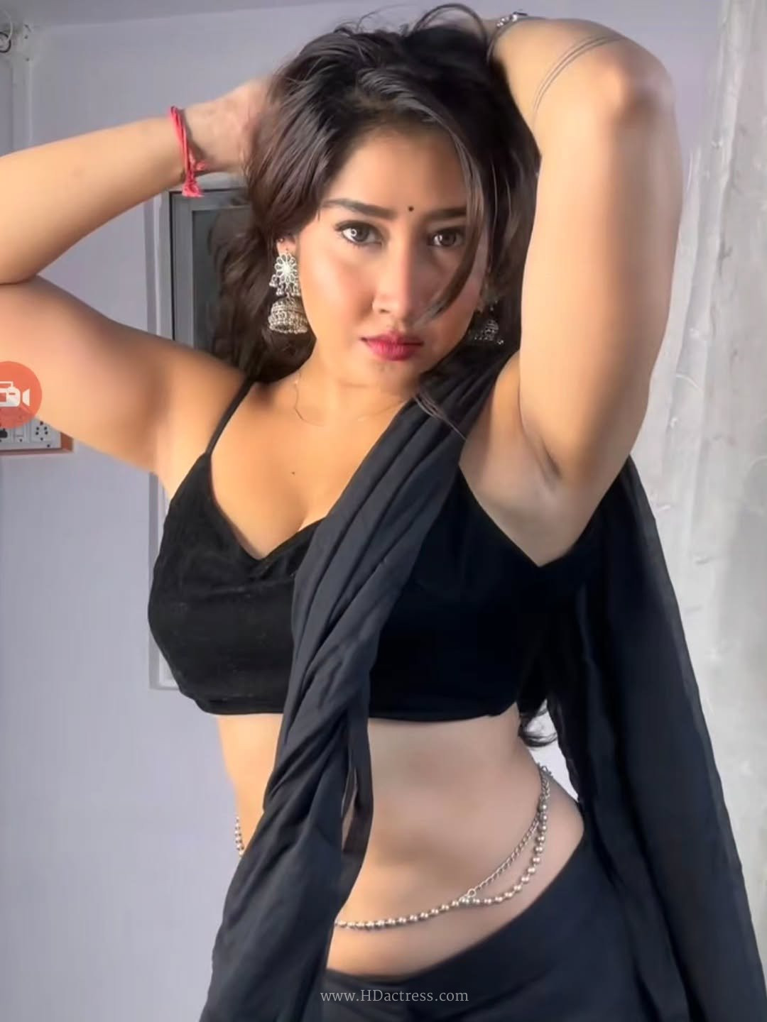 Sofia Ansari posing in a sheer black saree with a sleeveless blouse, traditional viral look.