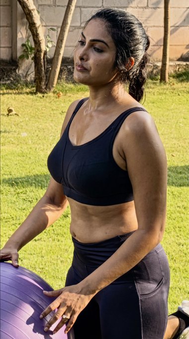 Actress Divi Vadthya posing in a stylish dark blue mesh sports bra during a professional fashion photoshoot.