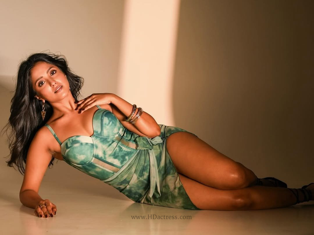 Actress Ulka Gupta posing confidently in a short black sweetheart neckline mini dress showing off her legs.