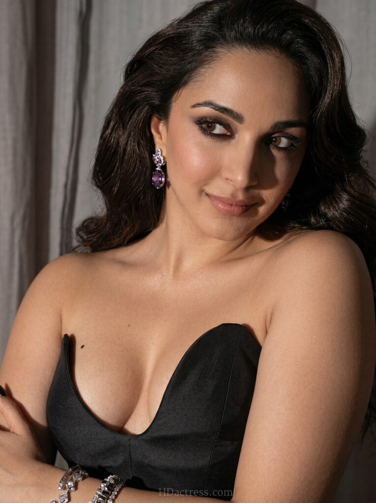Bollywood actress Kiara Advani posing confidently on the red carpet while wearing a fitted, low-cut black corset top that highlights her glamorous style.
