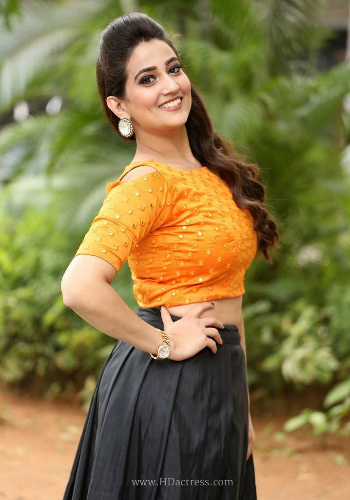 Manjusha in orange mirror blouse and black ethnic skirt