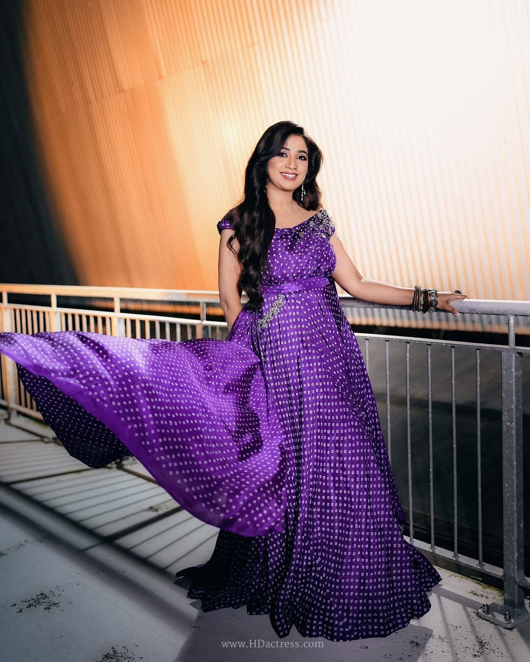 Shreya Ghoshal posing in an intricately embroidered traditional Indian choli top and lehenga set.