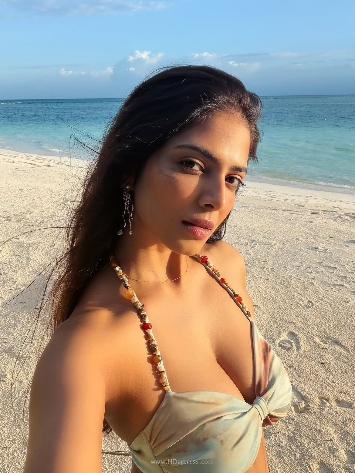 Actress Malavika Mohanan posing by the poolside in a chic neon green cutout