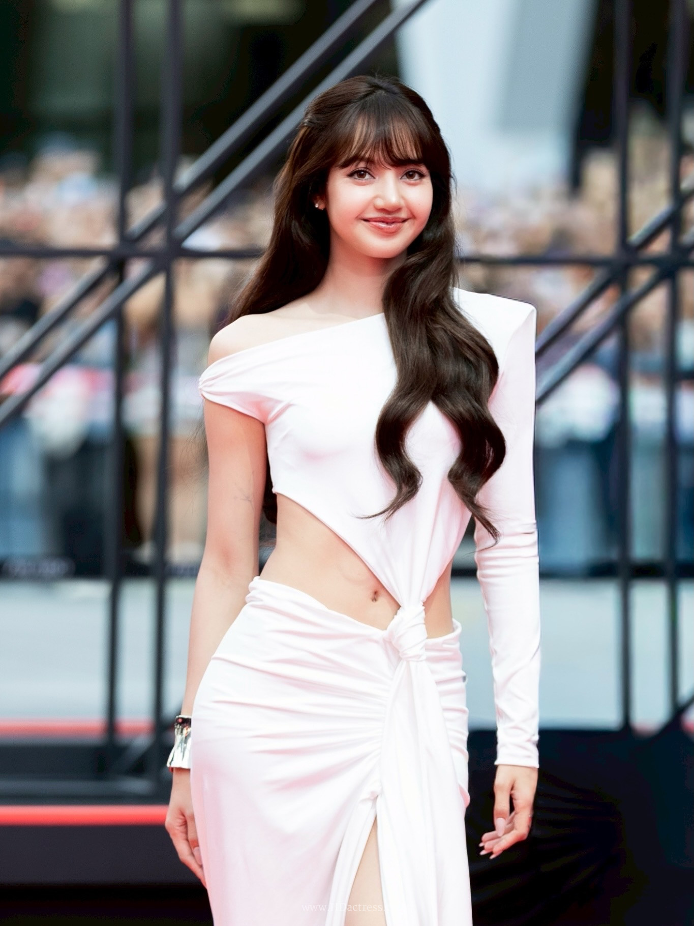BLACKPINK Lisa posing confidently in a high-fashion cutout dress showcasing her toned midriff.
