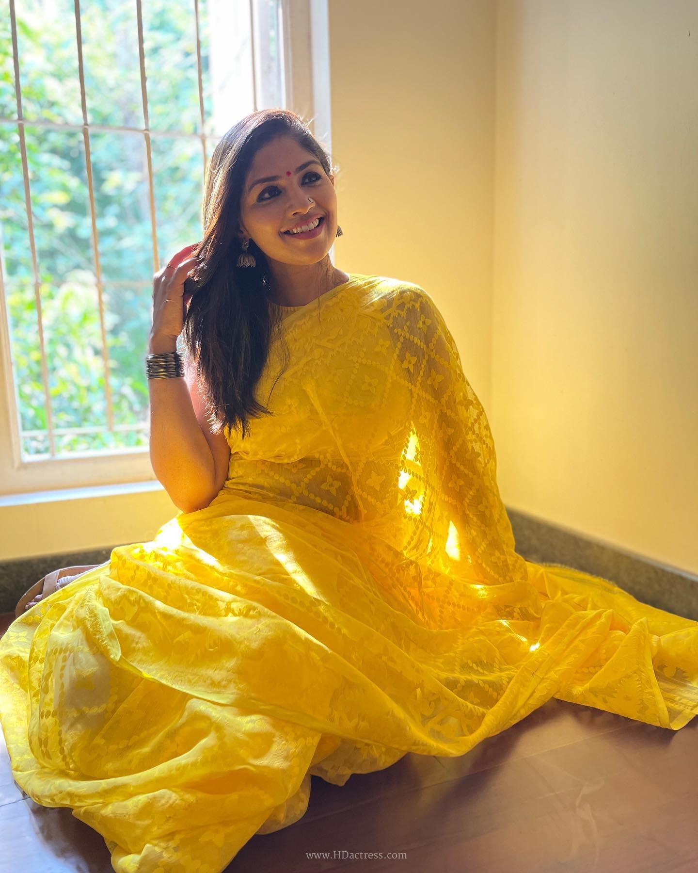 Roshini Vineeth in bright yellow organza saree
