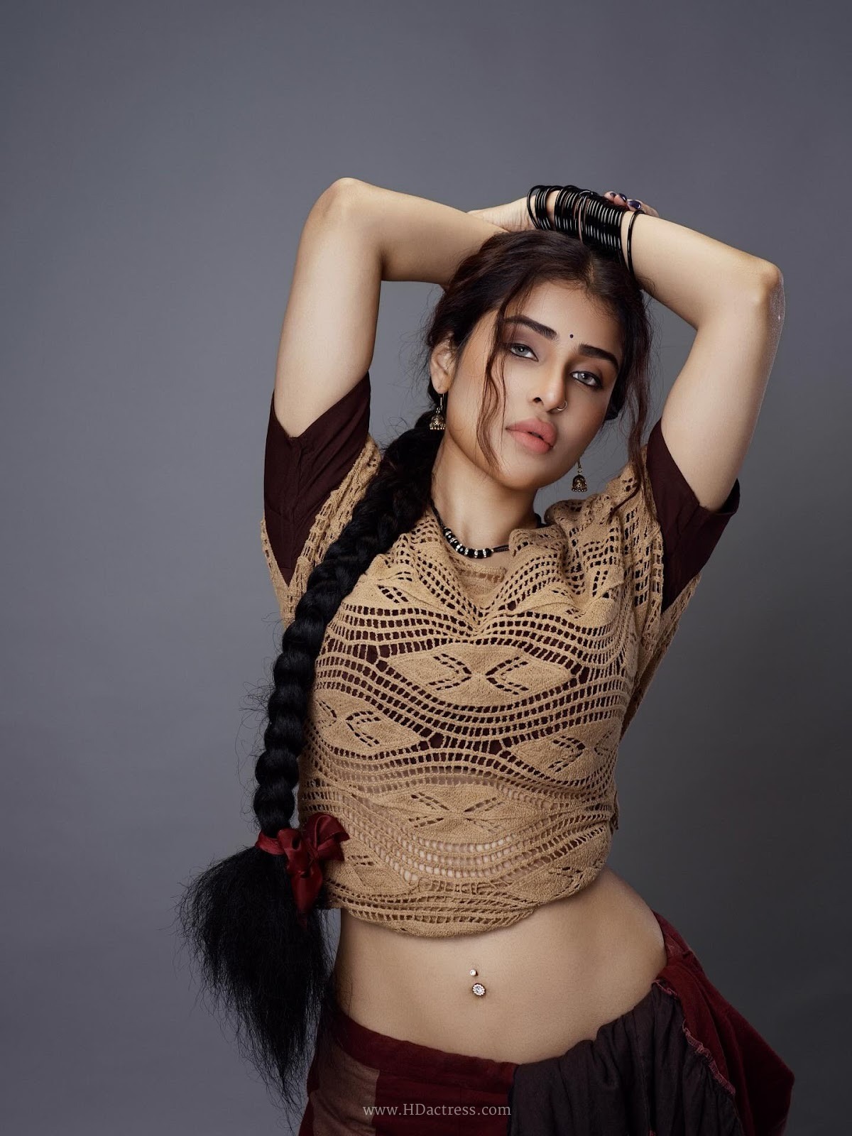 Edin Rose in tan crochet top and black draped skirt