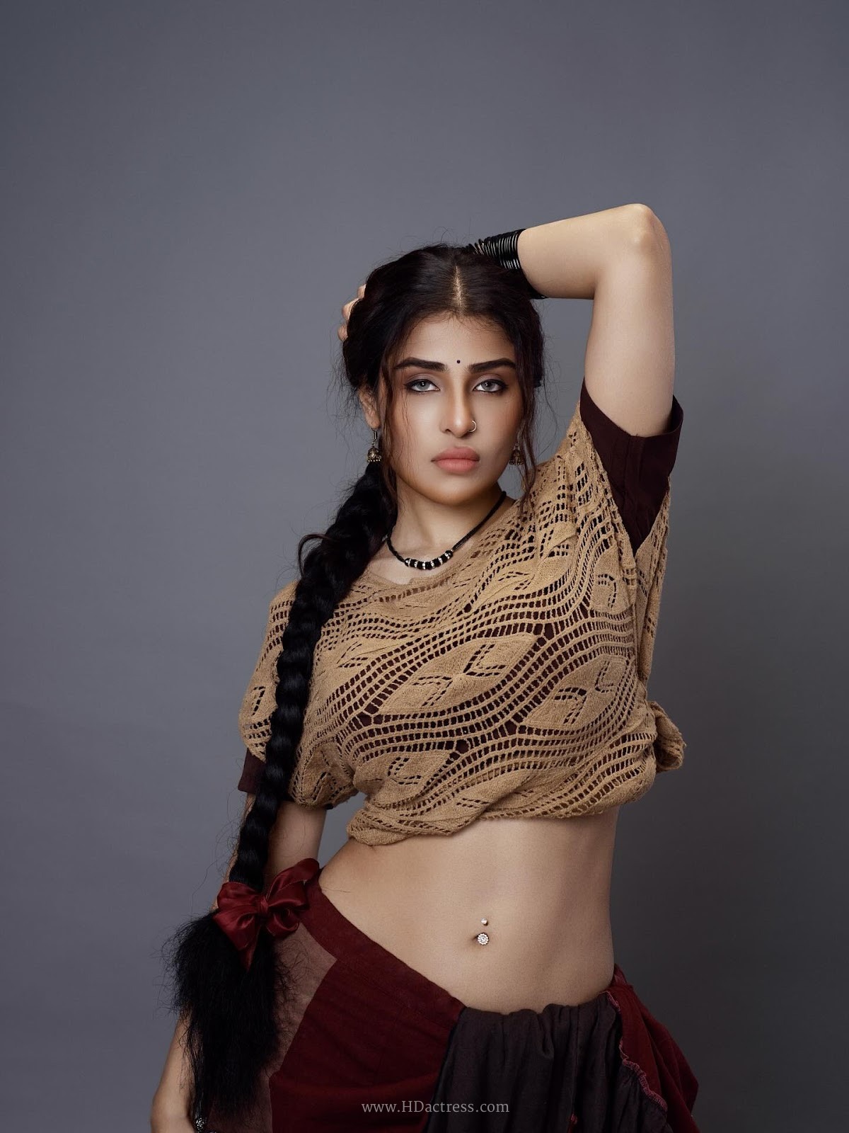 Edin Rose in tan crochet top and black draped skirt