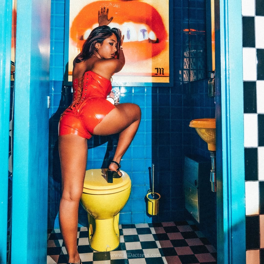 Sasha Prasad featuring a sleek strapless latex bodysuit in a high-fashion portrait setting.