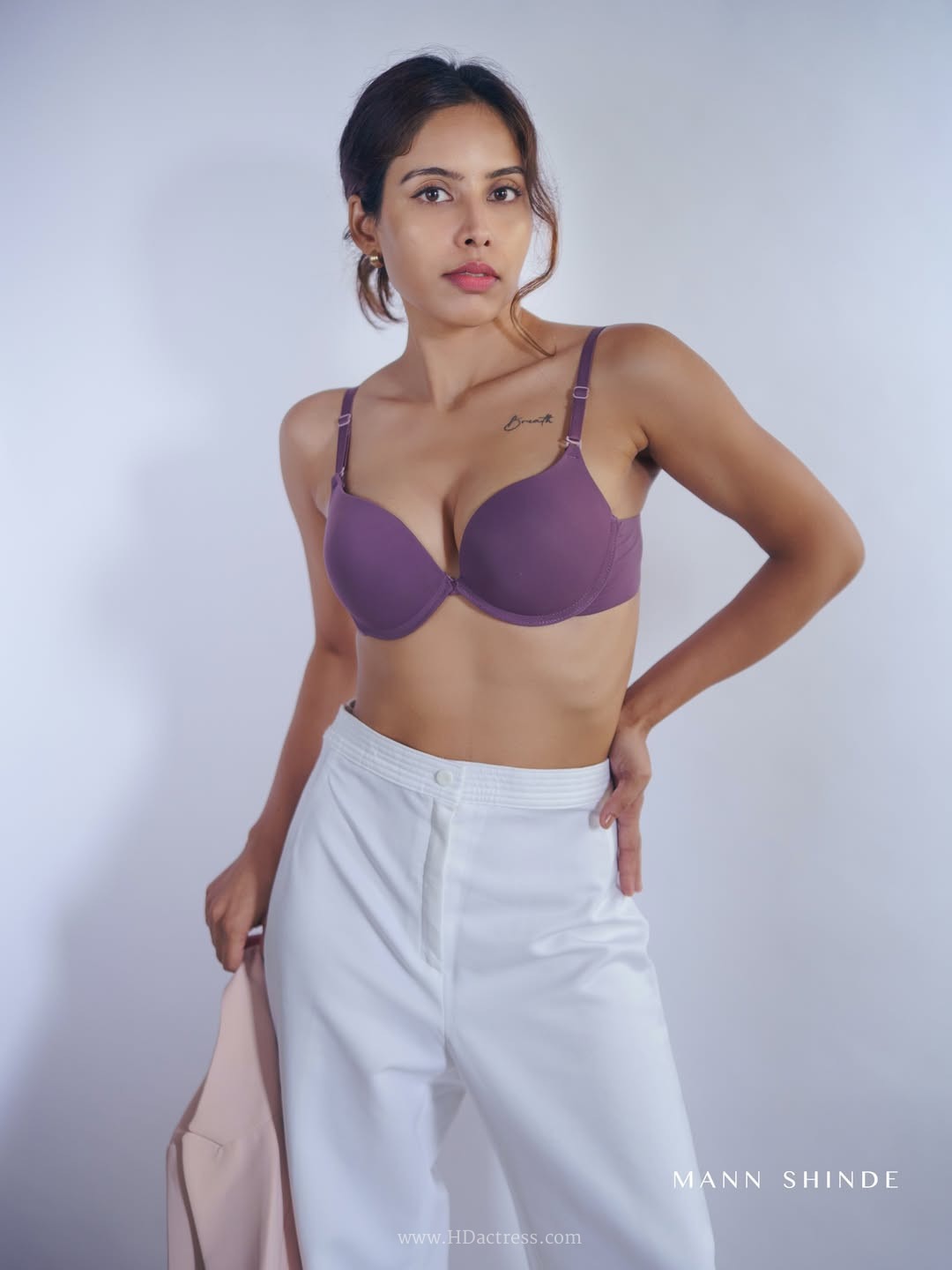 Esha Sana in a mauve top and high-waisted white trousers
