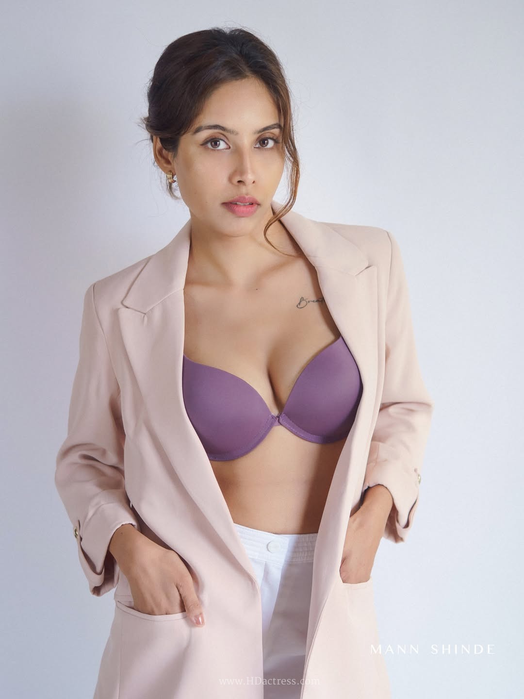 Esha Sana in a mauve top and high-waisted white trousers
