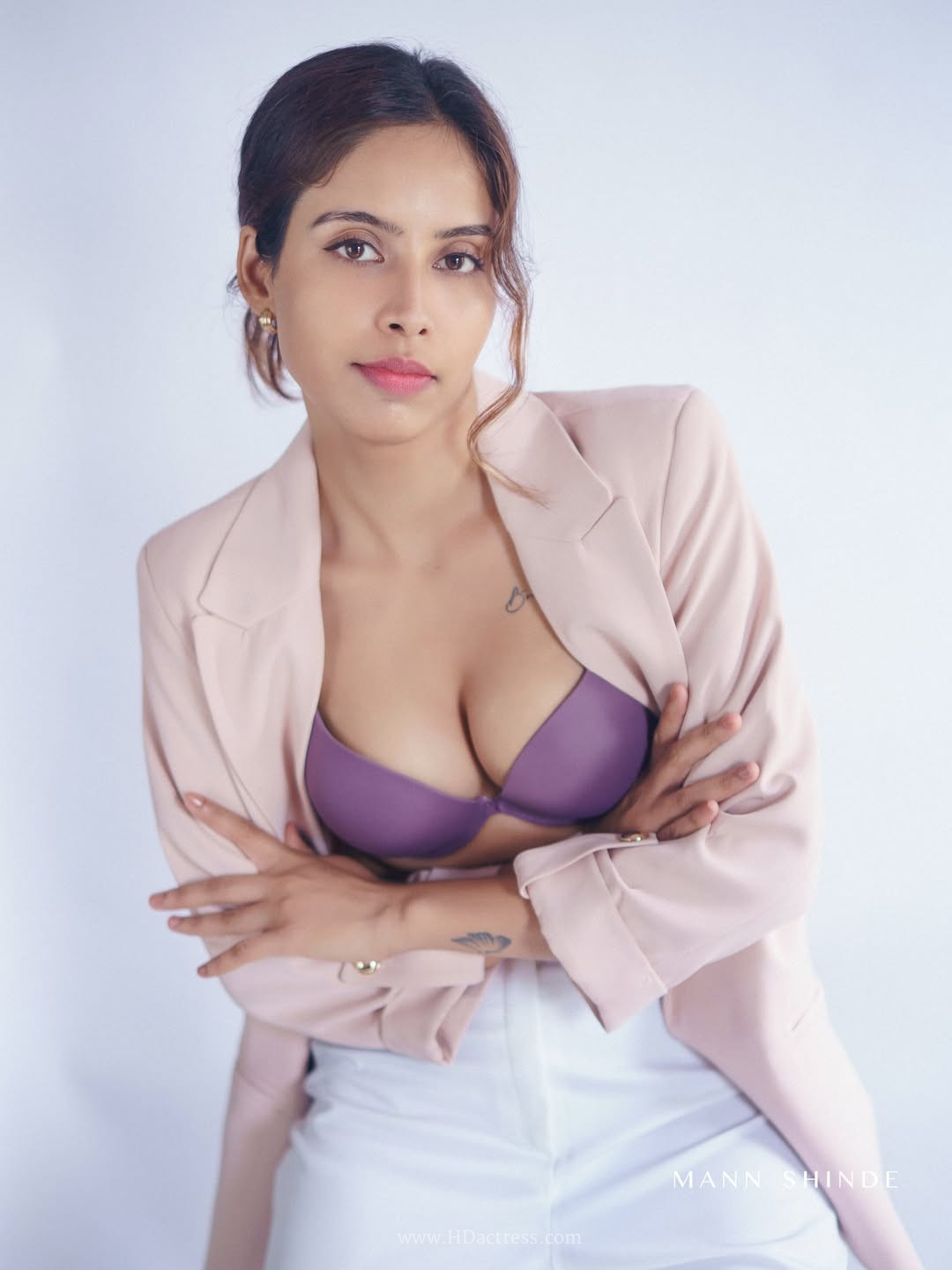 Esha Sana in a mauve top and high-waisted white trousers
