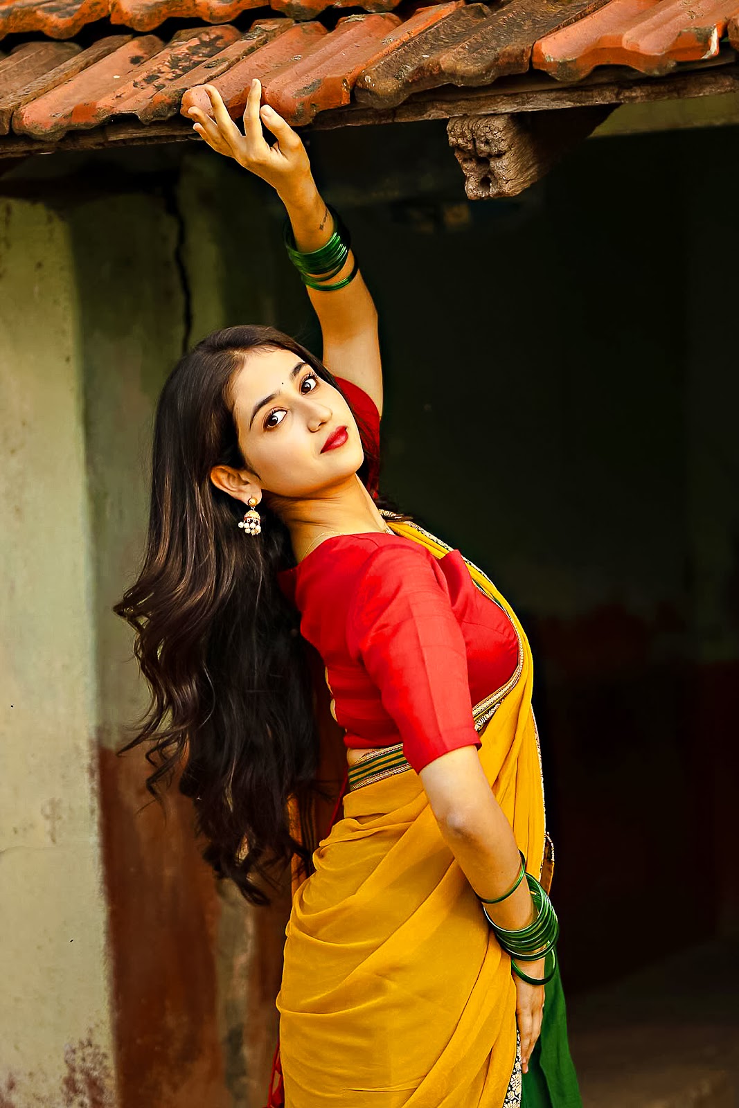 Malaika Vasupal Indian actress wearing a yellow and red outfit | Photo shoot images