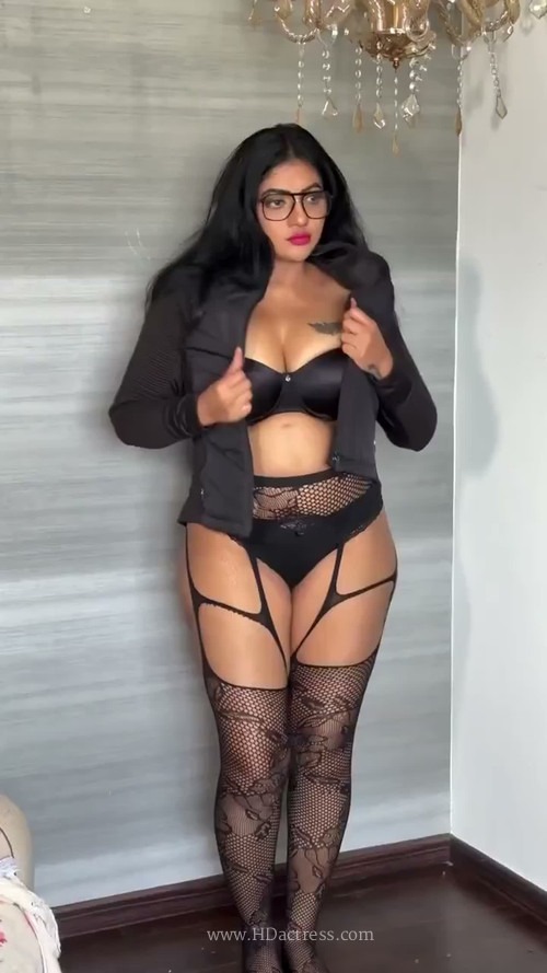 Reshma Pasupuleti posing confidently in a bold black lace lingerie set with garter straps.