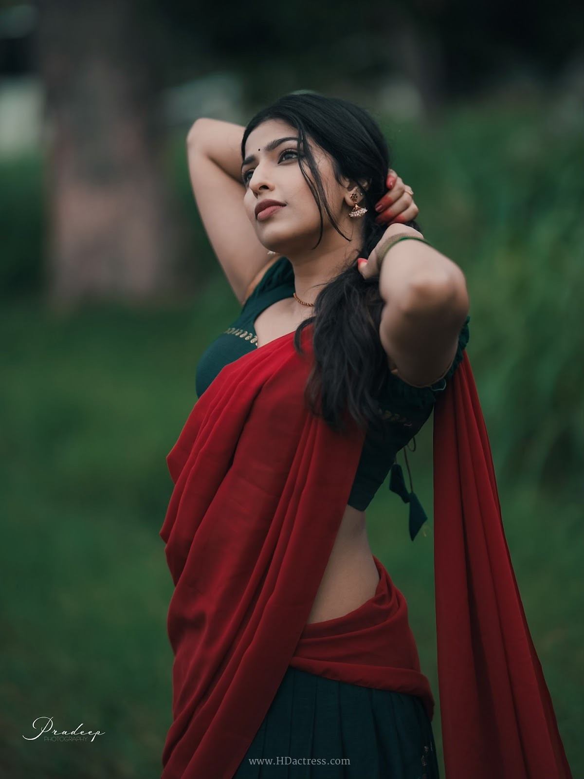 Raadya wearing a deep green blouse and crimson red half-saree