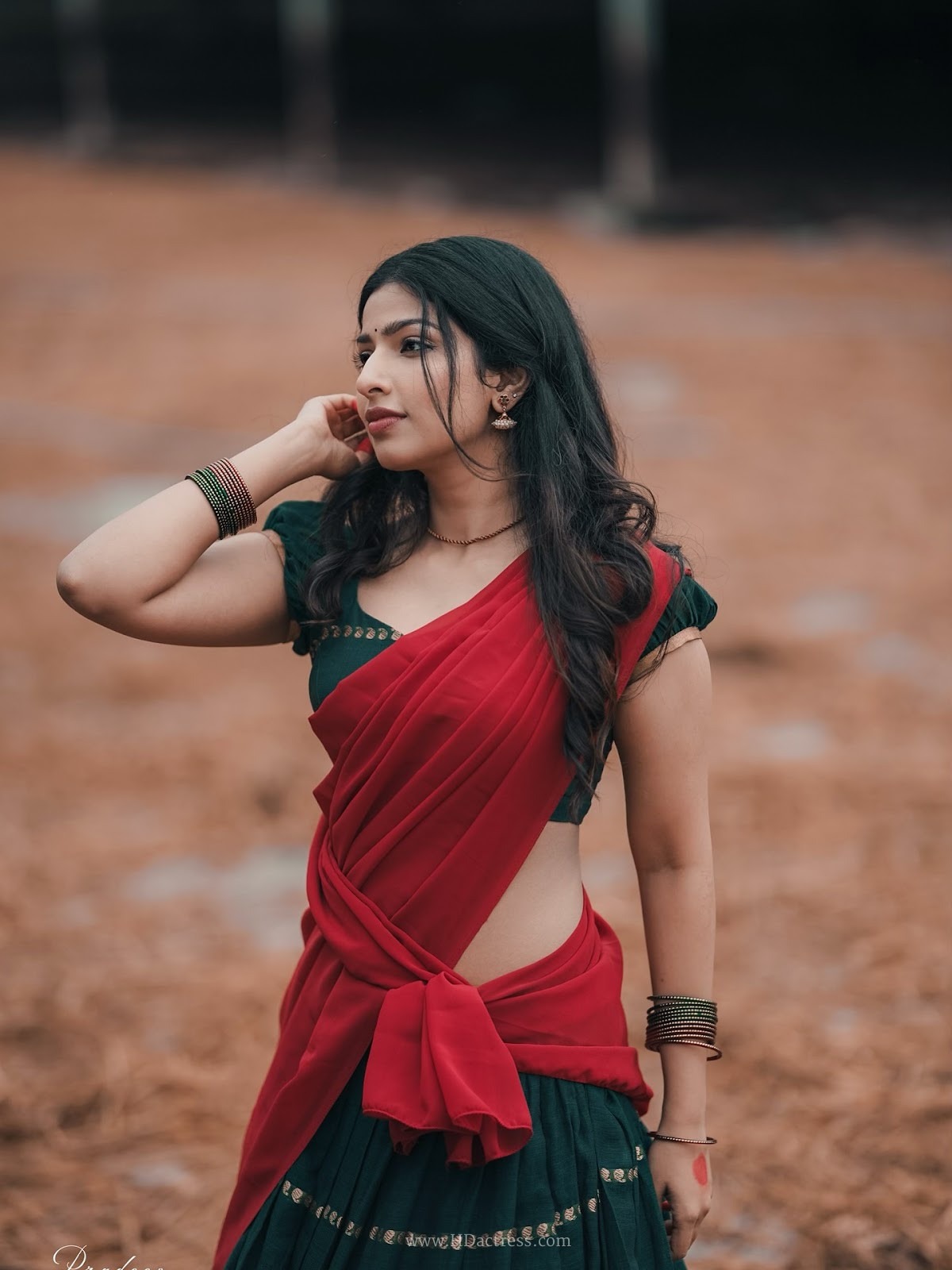 Raadya wearing a deep green blouse and crimson red half-saree