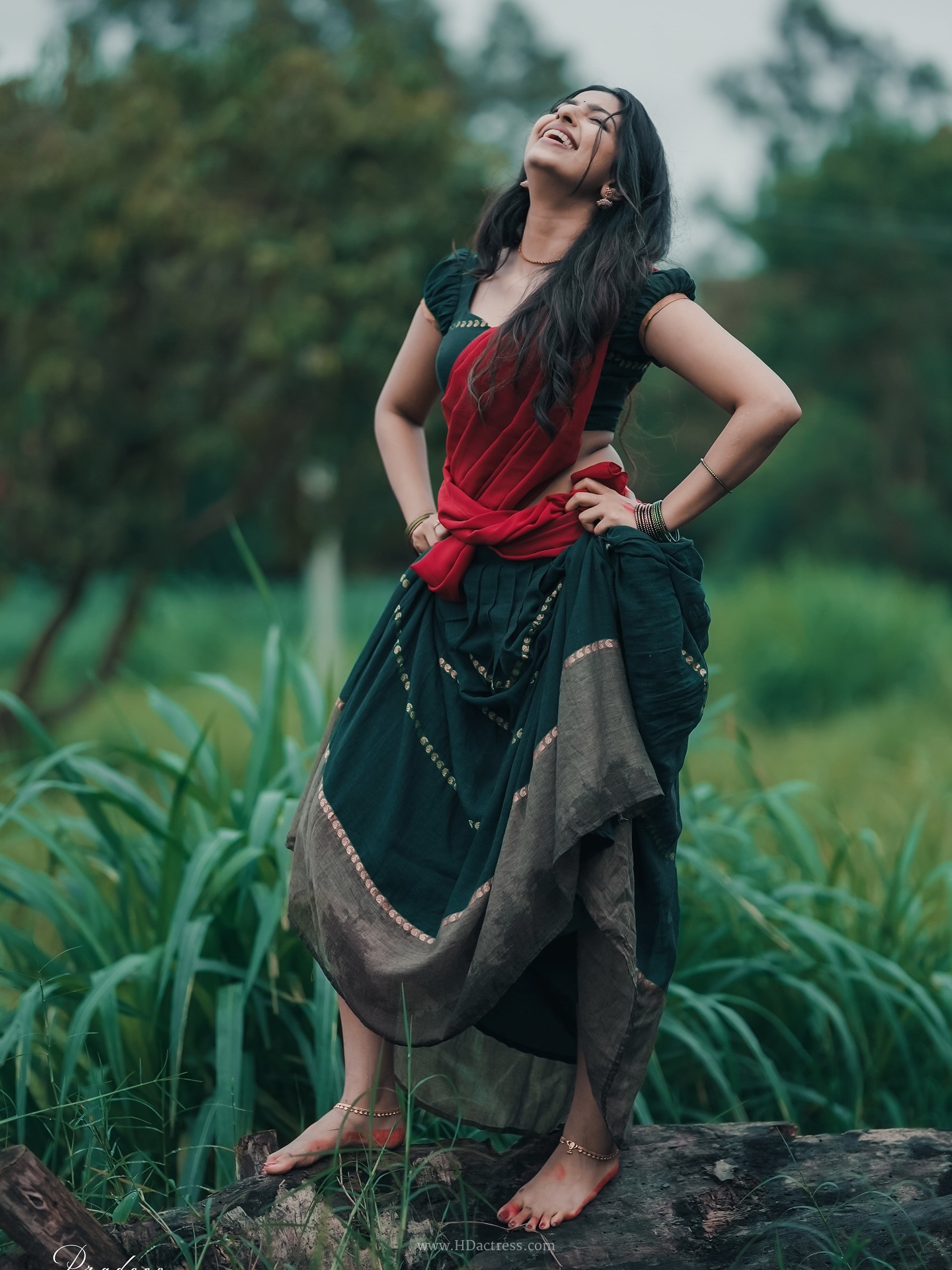 Raadya wearing a deep green blouse and crimson red half-saree