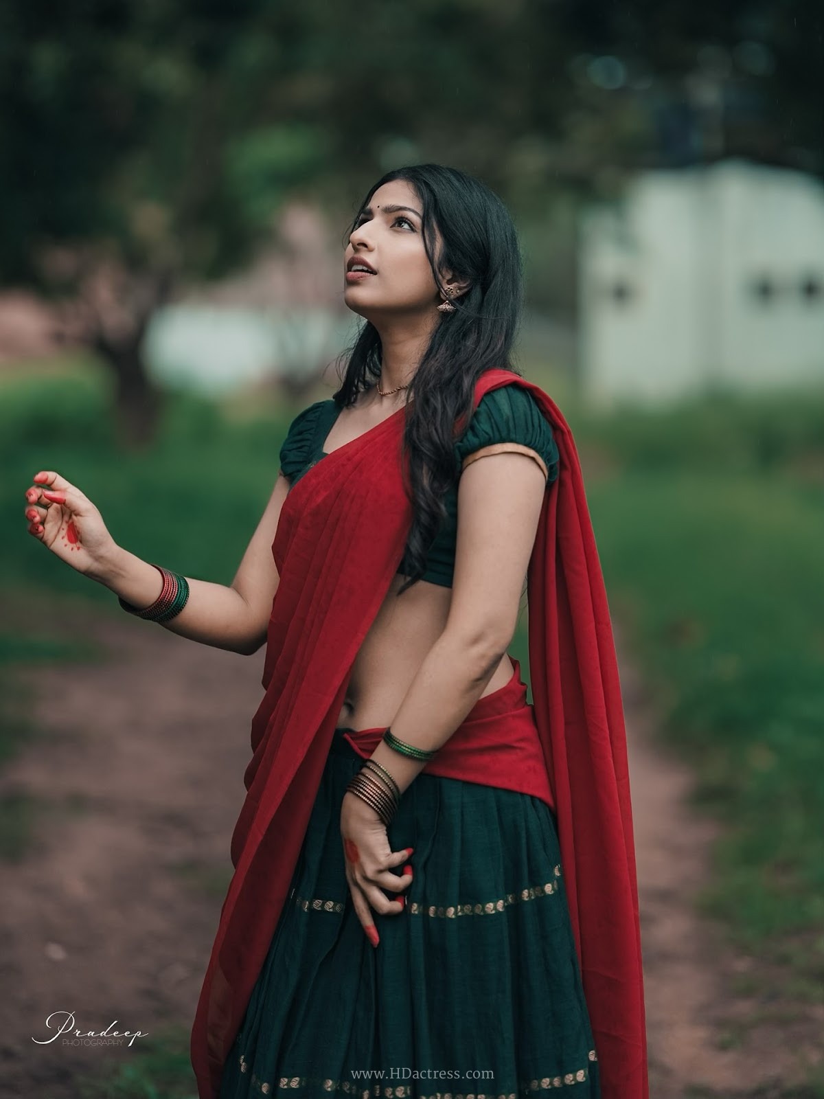 Raadya wearing a deep green blouse and crimson red half-saree