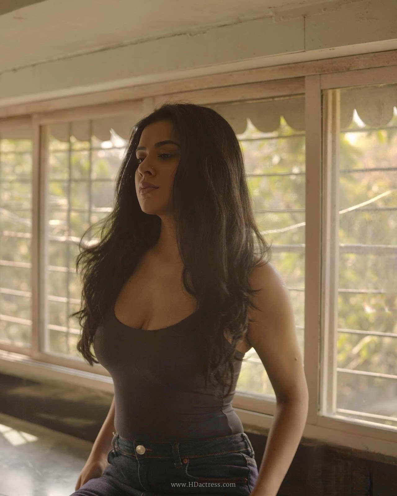 Nidhi Dudhraj wearing a charcoal grey camisole and dark blue jeans