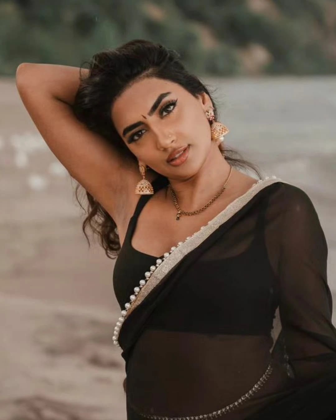 Vimzz K wearing a black chiffon saree and sleeveless blouse