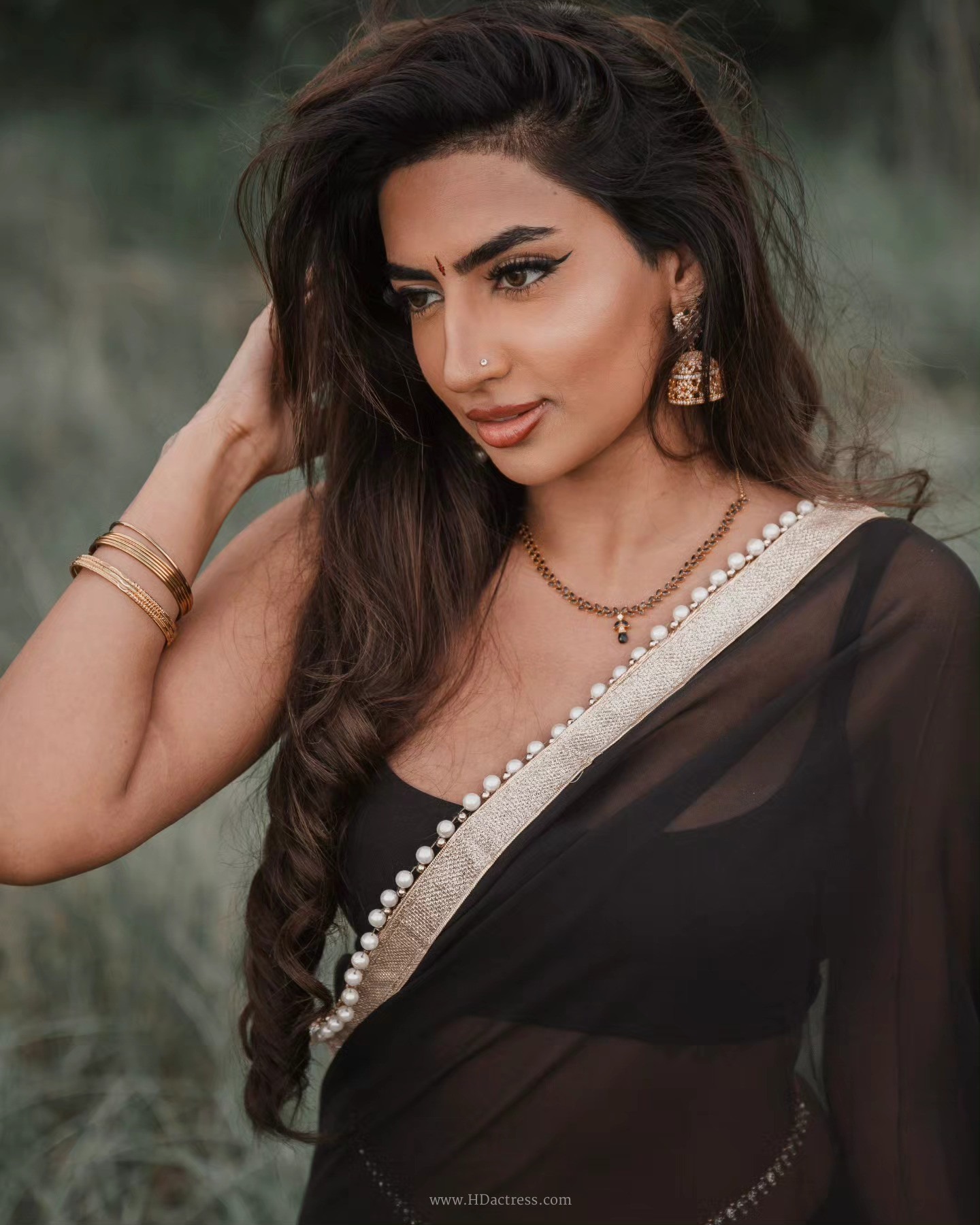 Vimzz K wearing a black chiffon saree and sleeveless blouse