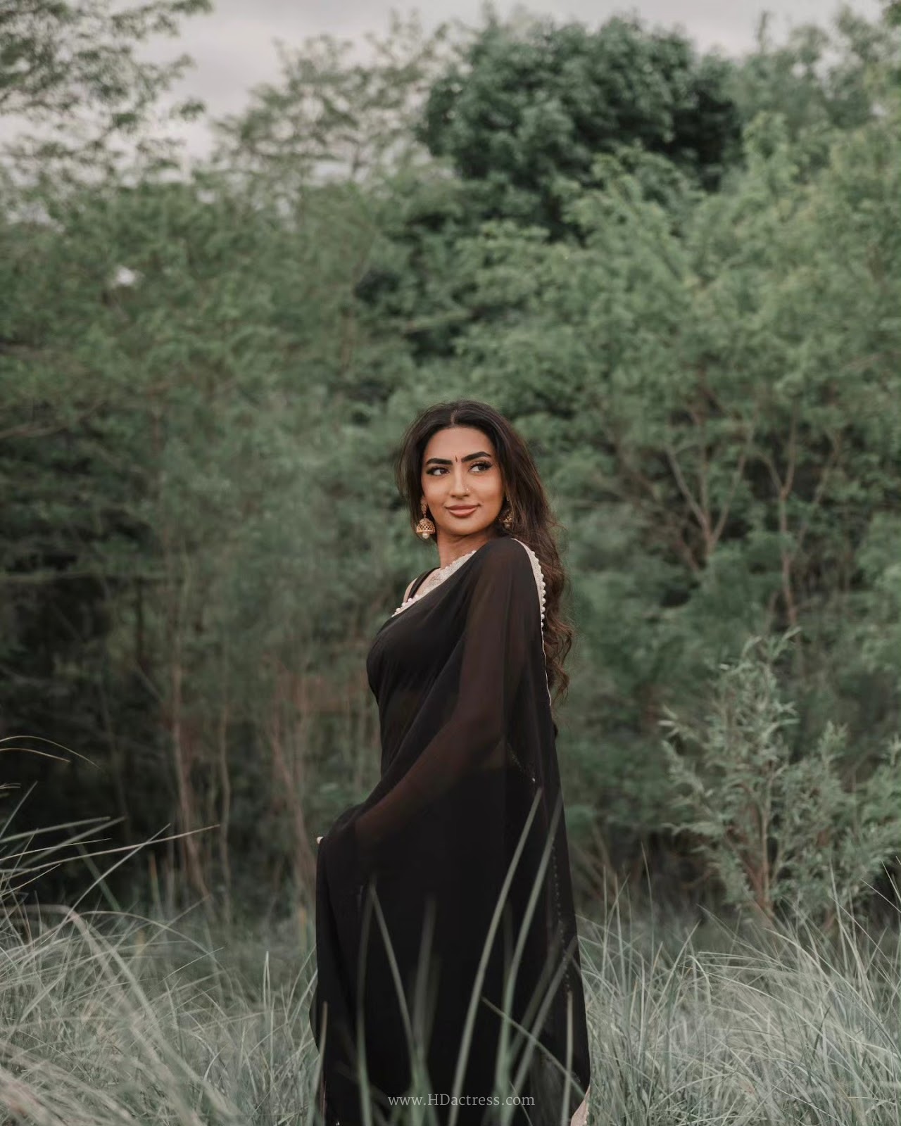Vimzz K wearing a black chiffon saree and sleeveless blouse