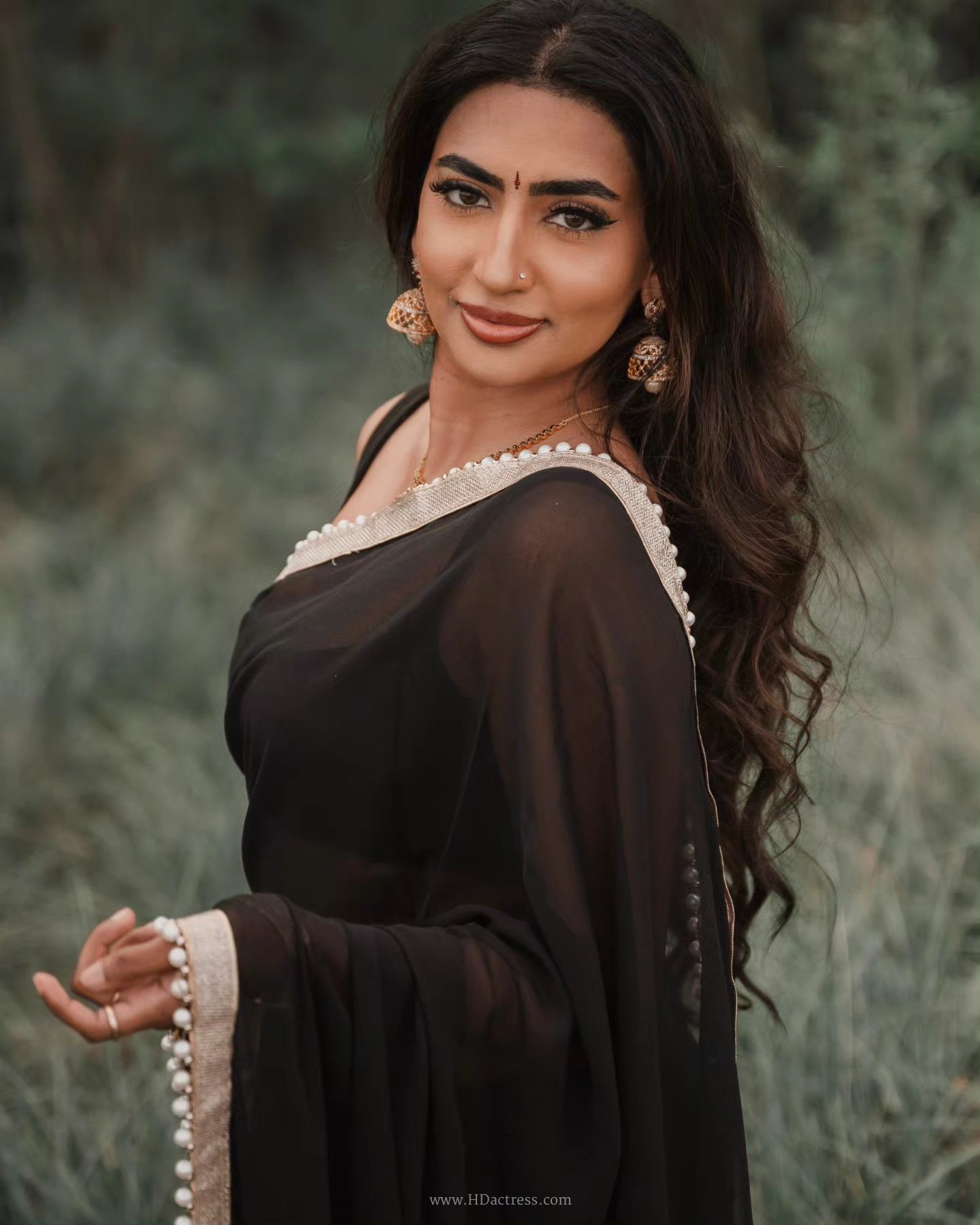 Vimzz K wearing a black chiffon saree and sleeveless blouse