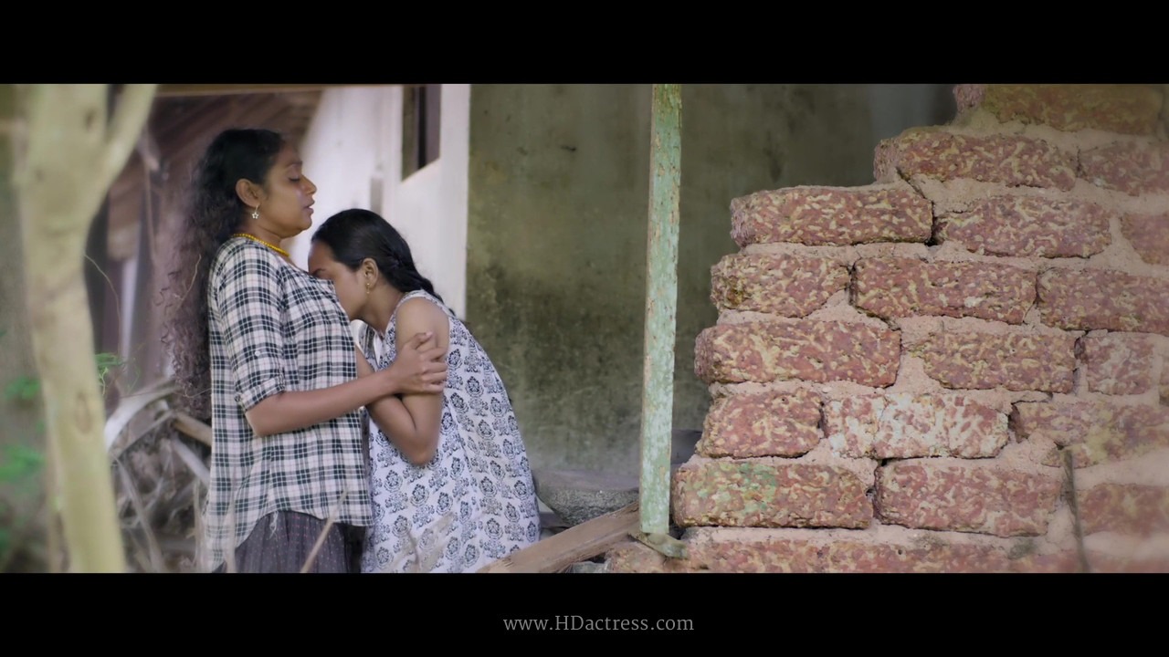 Janaki Sudheer and Amrita Vinod sharing an intimate glance in Holy Wound romance scene, Janaki Sudheer close-up looking vulnerable and radiant during Holy Wound emotional moment, Amrita Vinod as the nun locking eyes with Janaki Sudheer in a quiet passionate frame from Holy Wound  

